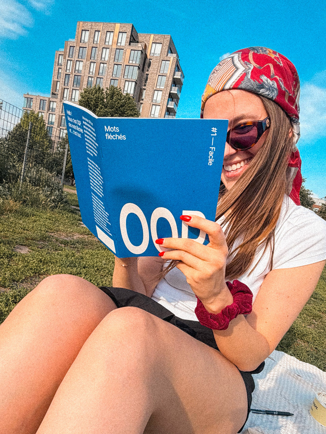 Le livret OQP #1 lu au soleil dans un parc